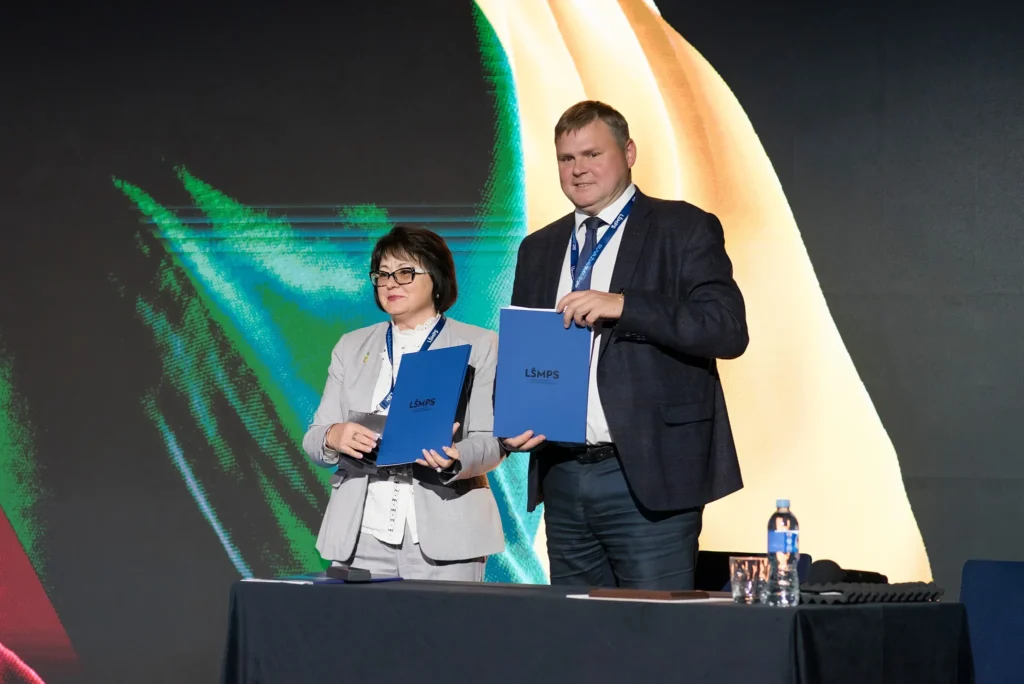 Чоловік і жінка з папками Lifecell на сцені партнерської події КПІ