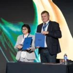 Чоловік і жінка з папками Lifecell на сцені партнерської події КПІ