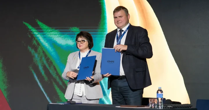 Чоловік і жінка з папками Lifecell на сцені партнерської події КПІ