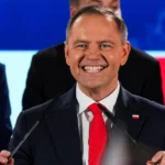 Кароль Навроцький усміхається на трибуні під час виступу з рекордним рейтингом