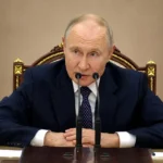 Володимир Путін за столом з мікрофонами під час заяви про Україну