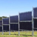 Сонячні панелі встановлені як паркан на зеленому полі