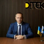 Максим Тимченко из ДТЭК за столом в офисе компании с флагами Украины и ЕС