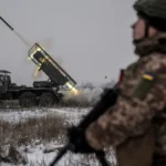 Український військовий спостерігає за пуском ракети на фронті