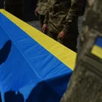 Труна загиблого військового під прапором України під час репатріації тіл