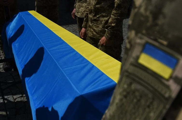 Труна загиблого військового під прапором України під час репатріації тіл