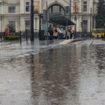 Дощі в Україні: мокрі вулиці та люди з парасольками біля зупинки