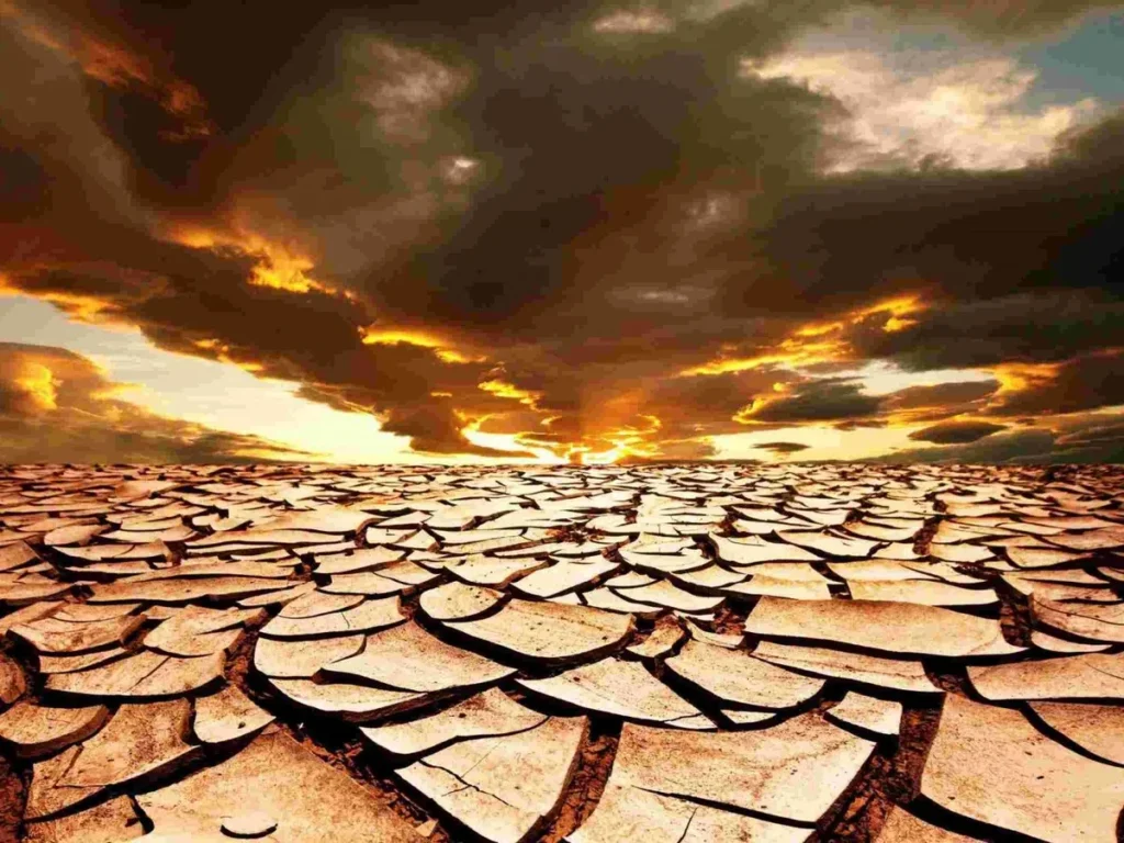 Потріскана висушена земля під хмарами екстремальної спеки 65°C