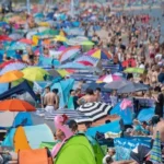 Переповнений пляж з яскравими парасольками під час липневих свят України