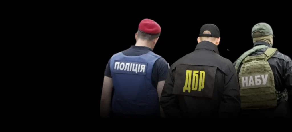 Працівники НАБУ, ДБР та поліції зі спинами до камери з логотипами на формі
