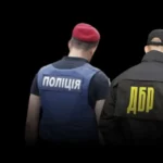 Працівники НАБУ, ДБР та поліції зі спинами до камери з логотипами на формі
