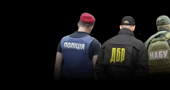 Працівники НАБУ, ДБР та поліції зі спинами до камери з логотипами на формі