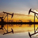 Нафтові качалки видобувають Urals на тлі заходу сонця