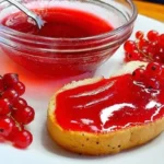 Варенье из красной смородины в миске и на хлебе с ягодами