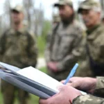 Офицер Сил обороны проверяет документы иностранных добровольцев
