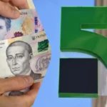 Руки тримають купюри 20 і 500 гривень біля зеленого логотипа ПриватБанку