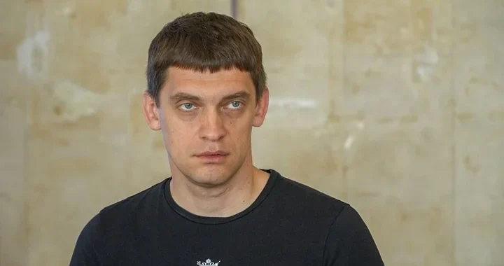 Іван Федоров у чорній футболці на тлі світлої камяної стіни