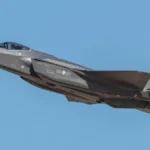 Сірий винищувач F-35A з німецьким прапором і номером 35+01 летить у небі