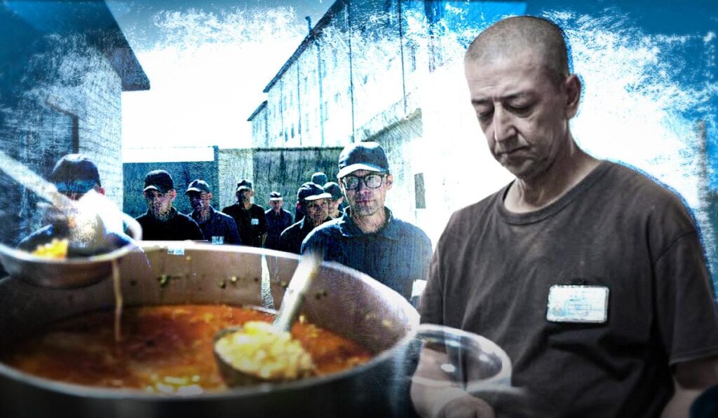 Чоловік розливає суп із великого казана, позаду група людей у дворі в’язниці