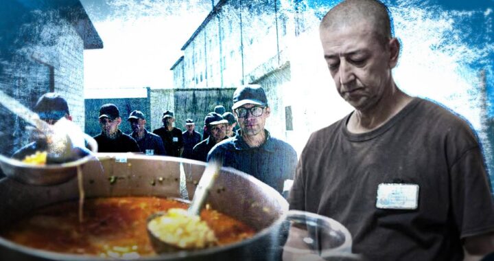 Чоловік розливає суп із великого казана, позаду група людей у дворі в’язниці