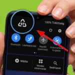 Рука тримає смартфон Samsung з панеллю налаштувань і виділеним трикутником зі стрілками