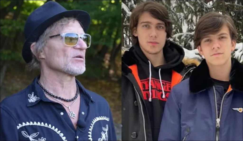 Олег Скрипка в капелюсі й окулярах і двоє юнаків на тлі дерев